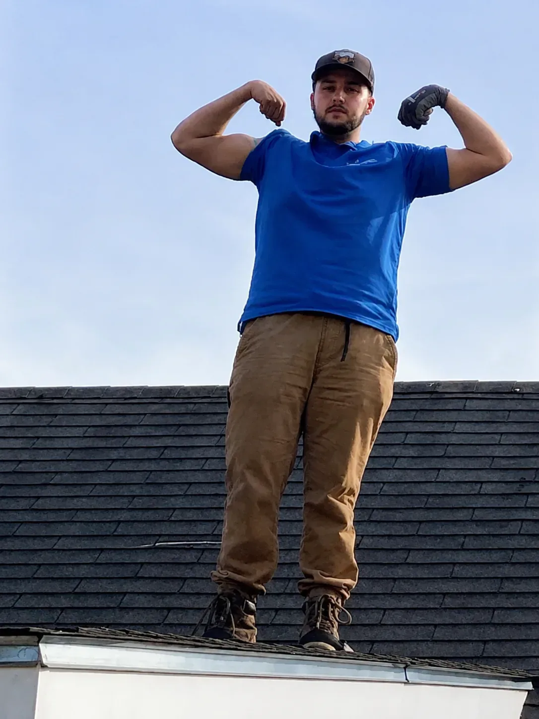 Josh on a rooftop, gloves on, arms flexed