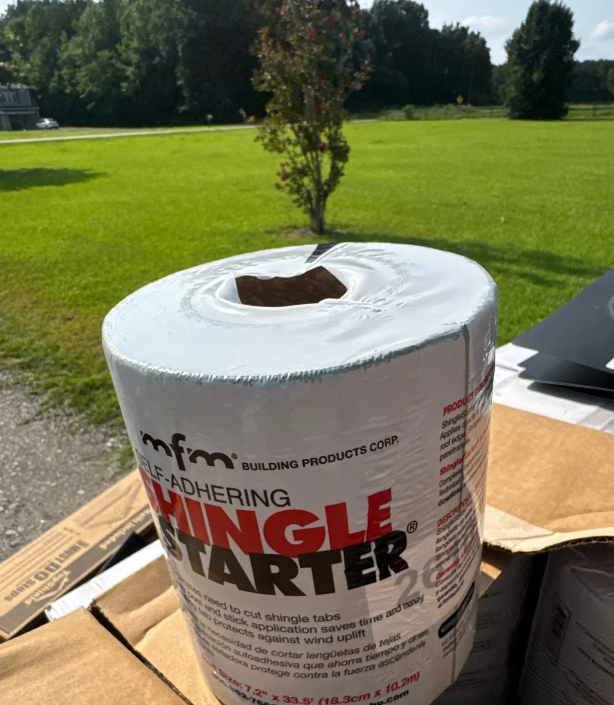 A roll of MFM self-adhering Shingle Starter on a Carolina Trophy Roofs job site, the fully adhered starter course used to lock down the roof edge against wind uplift