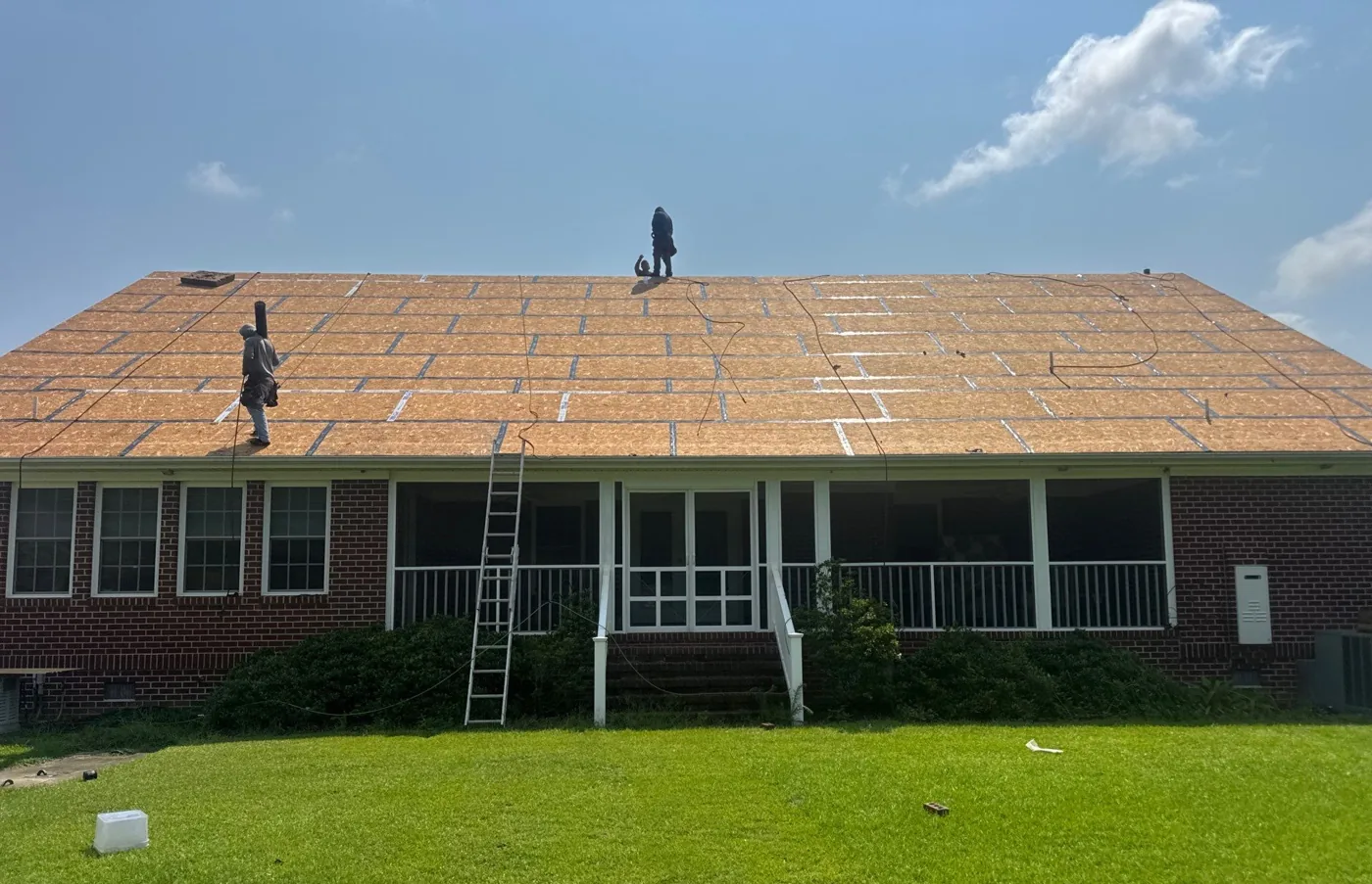 A brick ranch home in Eastern North Carolina stripped to bare roof decking with every deck seam taped and sealed across the whole slope, before underlayment and shingles are installed