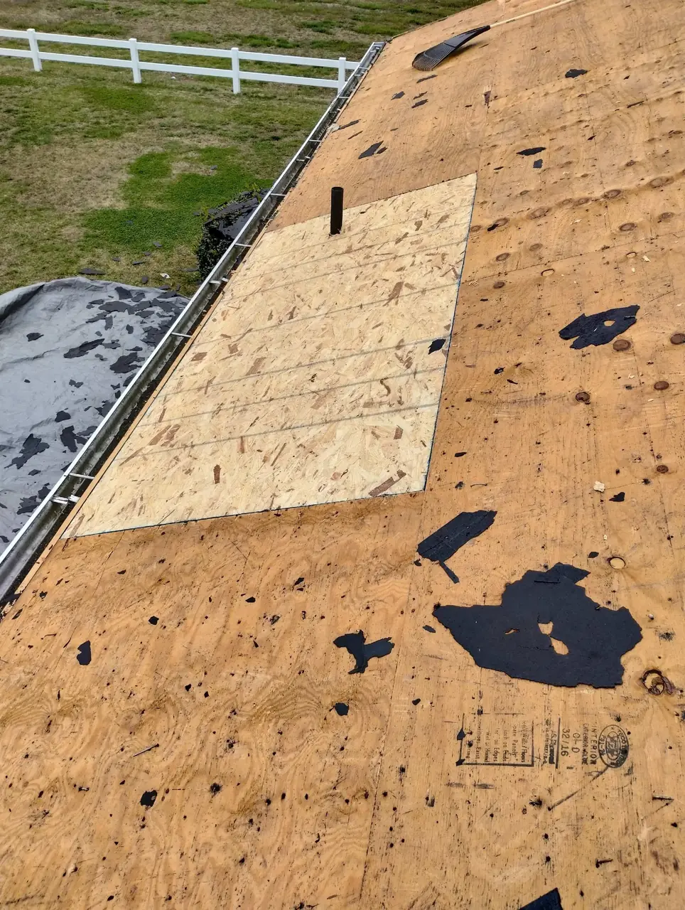 New OSB patch set into the old plywood roof deck of a brick ranch in Goldsboro, NC during a roof replacement
