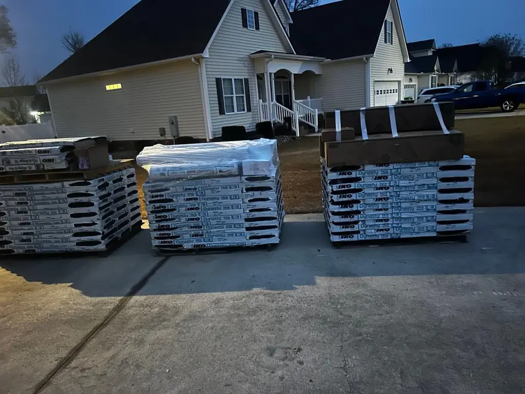 Pallets of IKO Dynasty architectural shingles delivered to a driveway in Winterville, NC before the re-roof