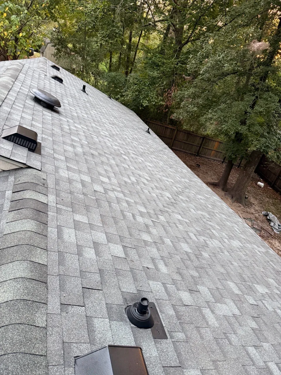 New light gray architectural shingles with box vents, a turbine vent and a pipe boot on a roof in Jacksonville, NC