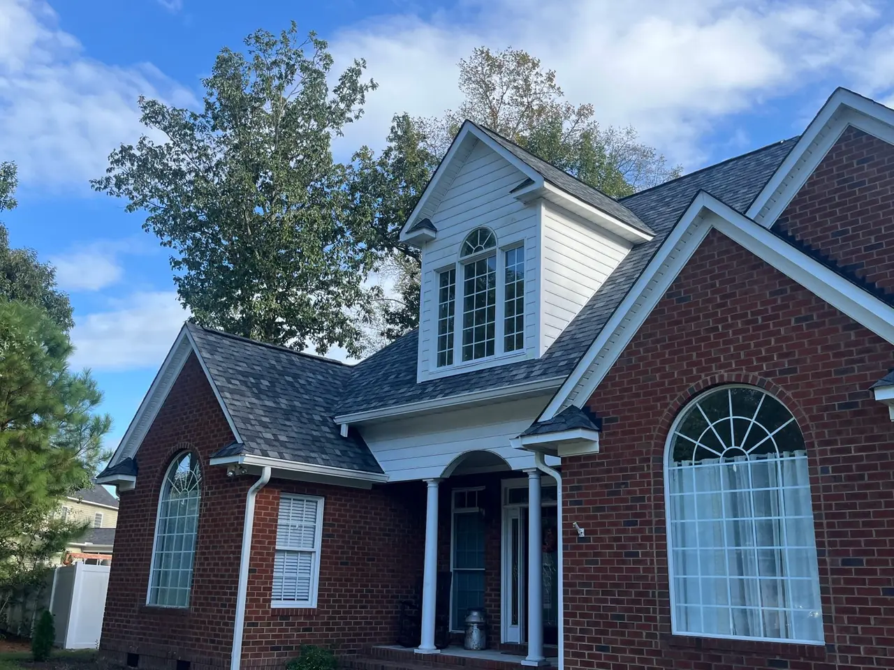 Brick home in Trent Woods, NC with a front dormer, arched windows and a new charcoal architectural shingle roof