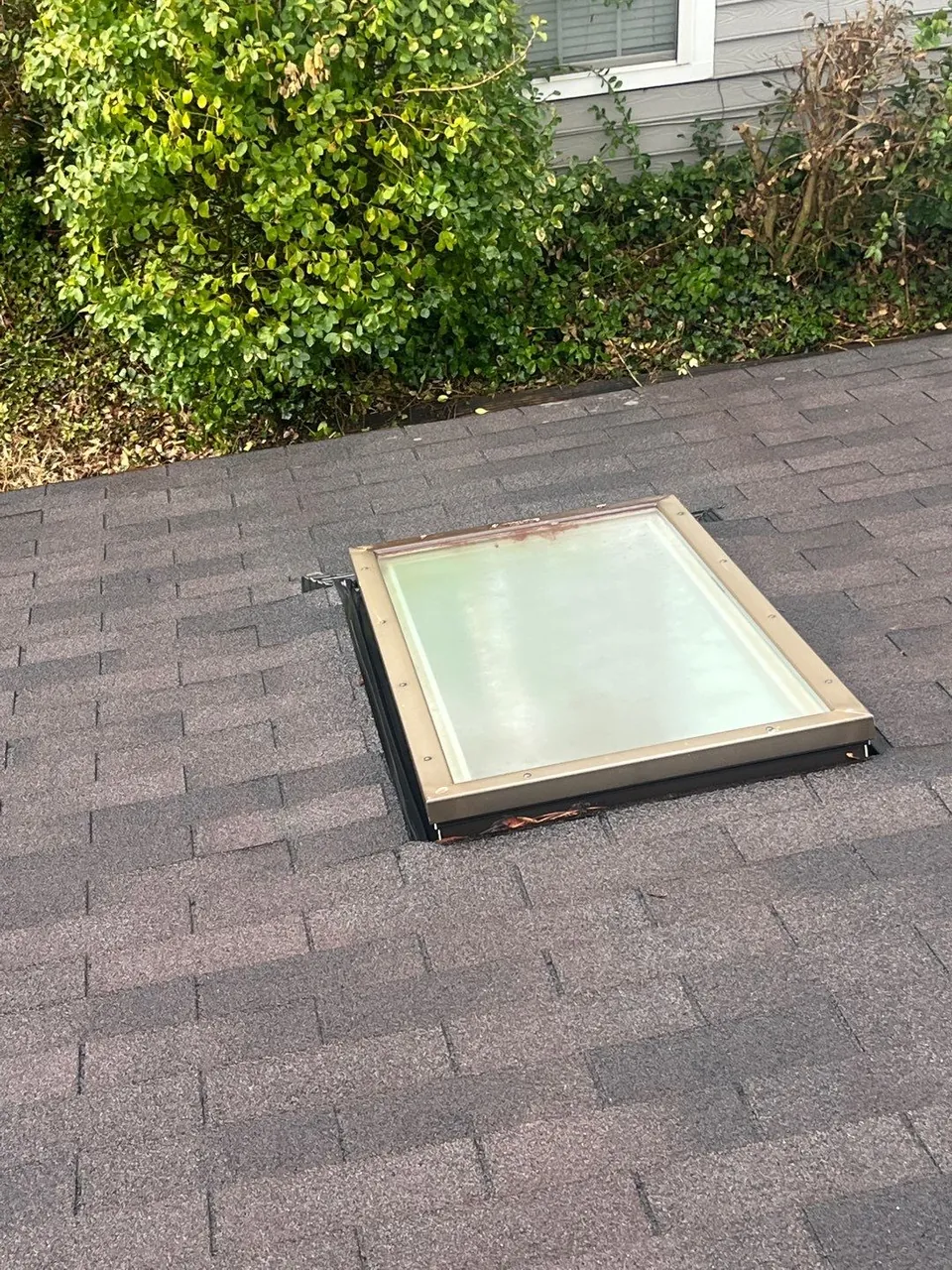 Skylight and its flashing on the lower shingle roof of a Raleigh, NC home, photographed during an inspection