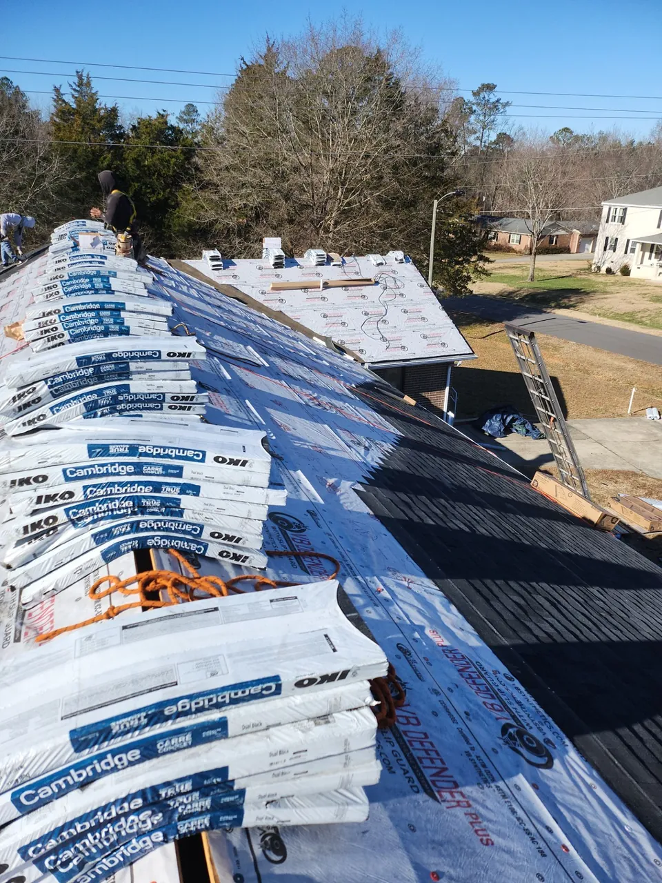 Bundles of IKO Cambridge shingles loaded along the ridge of a church roof over synthetic underlayment in Wake Forest, NC