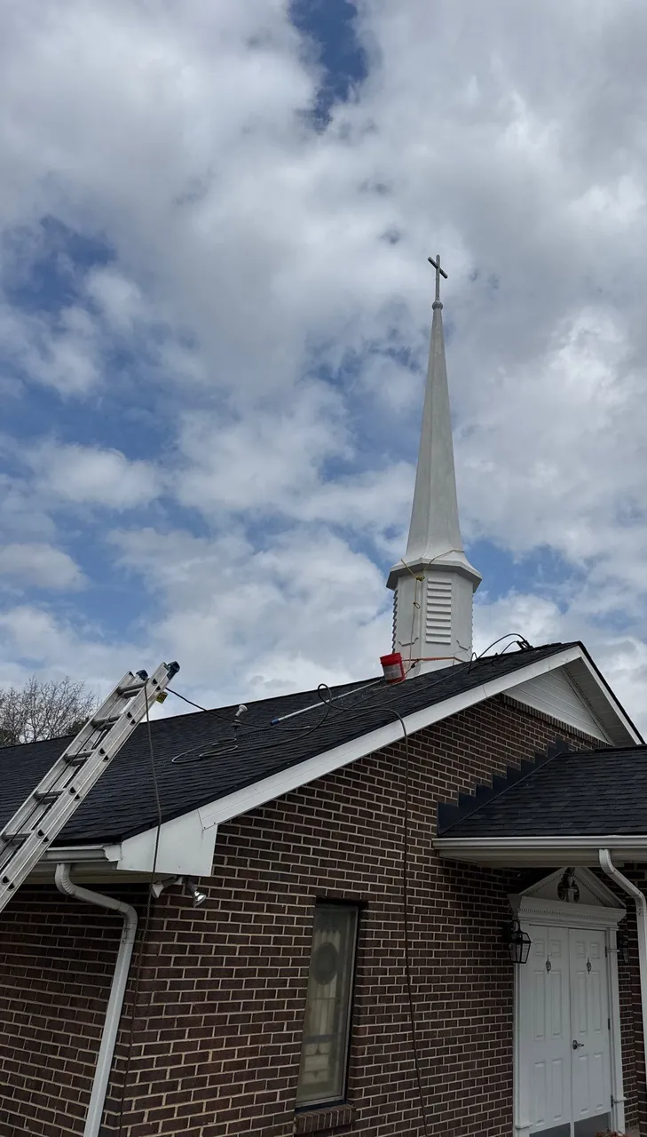 Brick church in Wake Forest, NC with a white steeple and a new dark architectural shingle roof