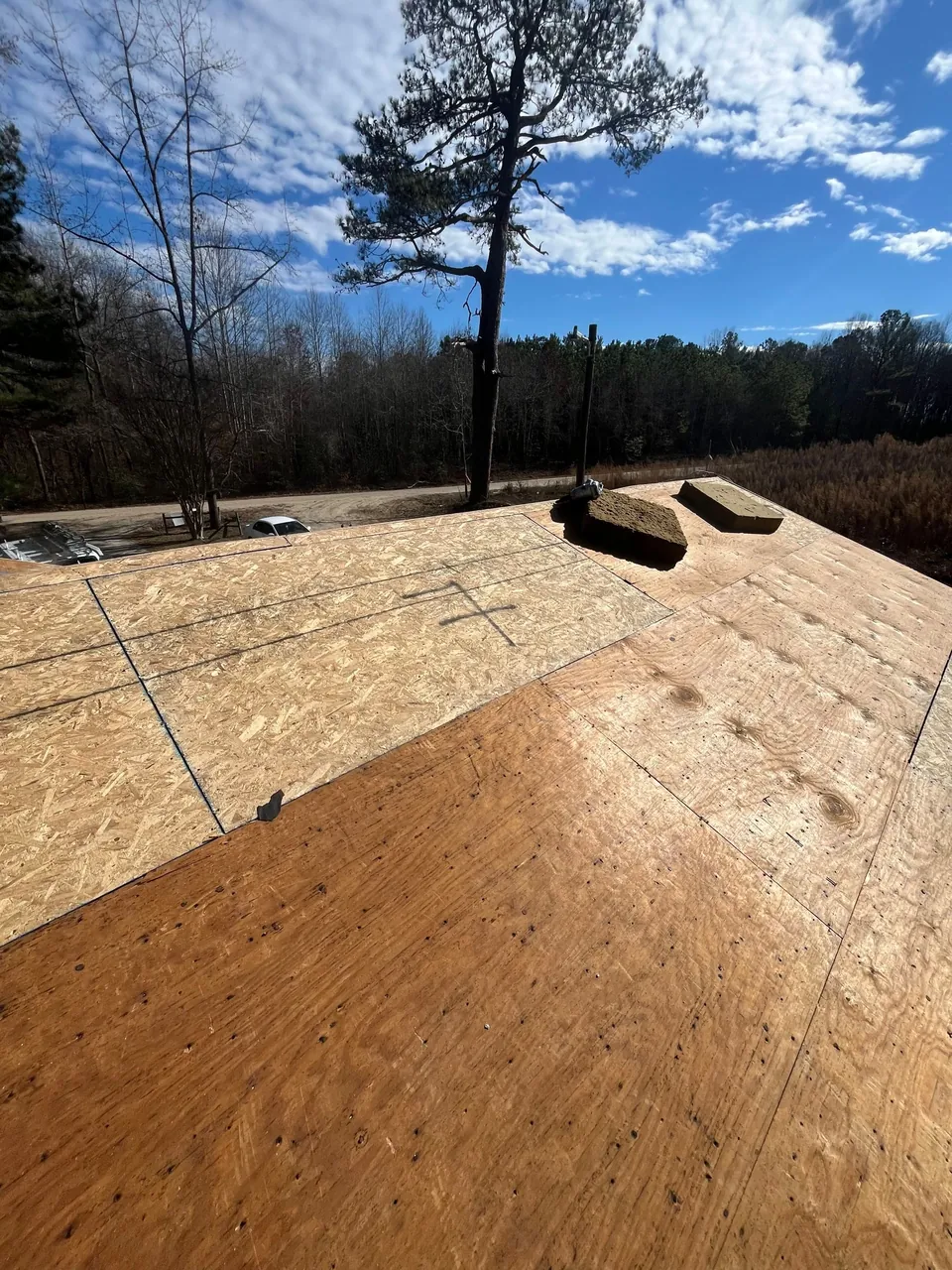 New OSB sheathing set into an older plywood roof deck during a roof replacement in Enfield, NC