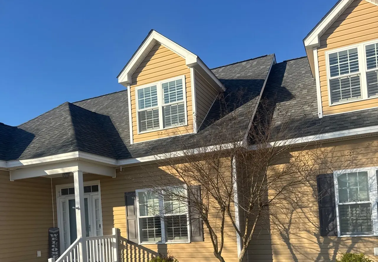 Home in Nashville, NC with three dormers and a new charcoal architectural shingle roof under a clear blue sky