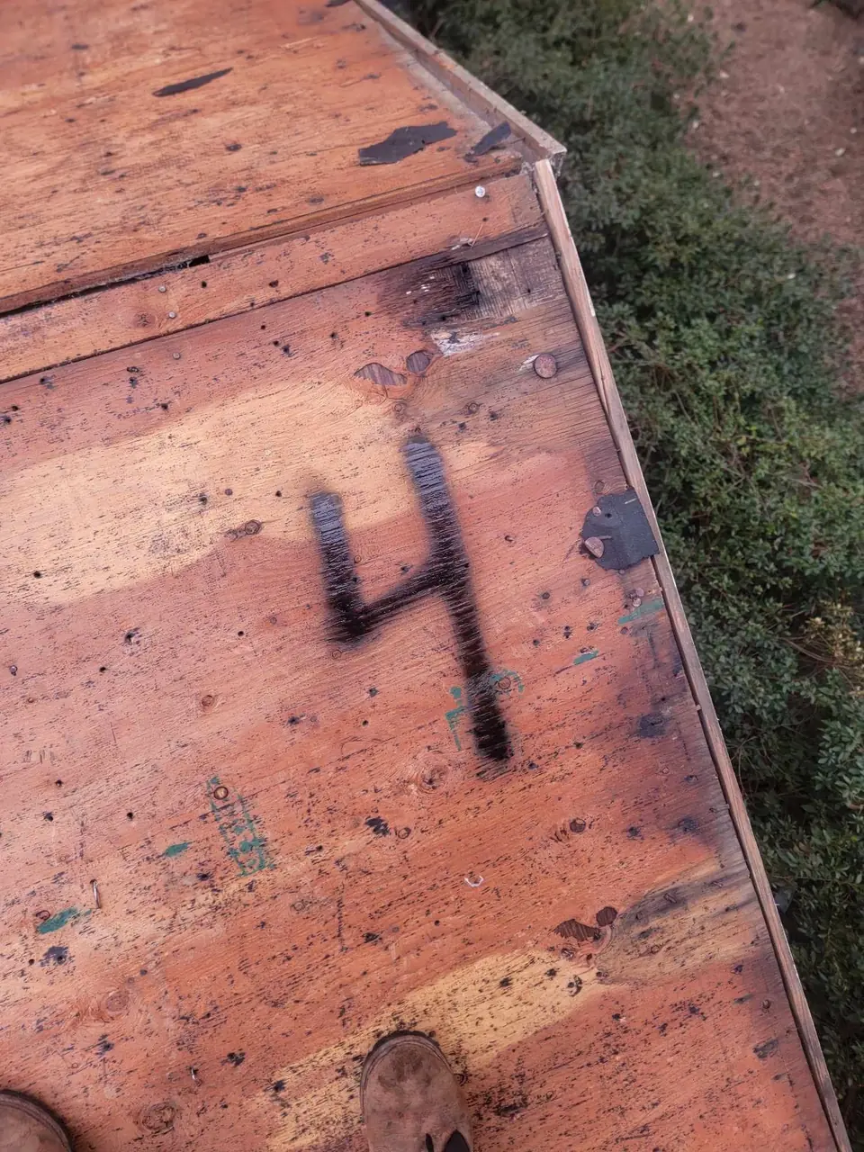 Bare plywood roof deck with a spray-painted number on it during a roof tear-off in Rocky Mount, NC