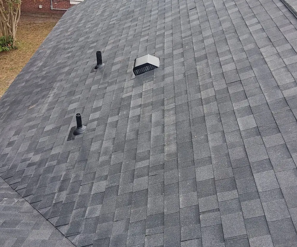 Two pipe vents and a box roof vent set into new shingles on the main slope of a Rocky Mount, NC roof