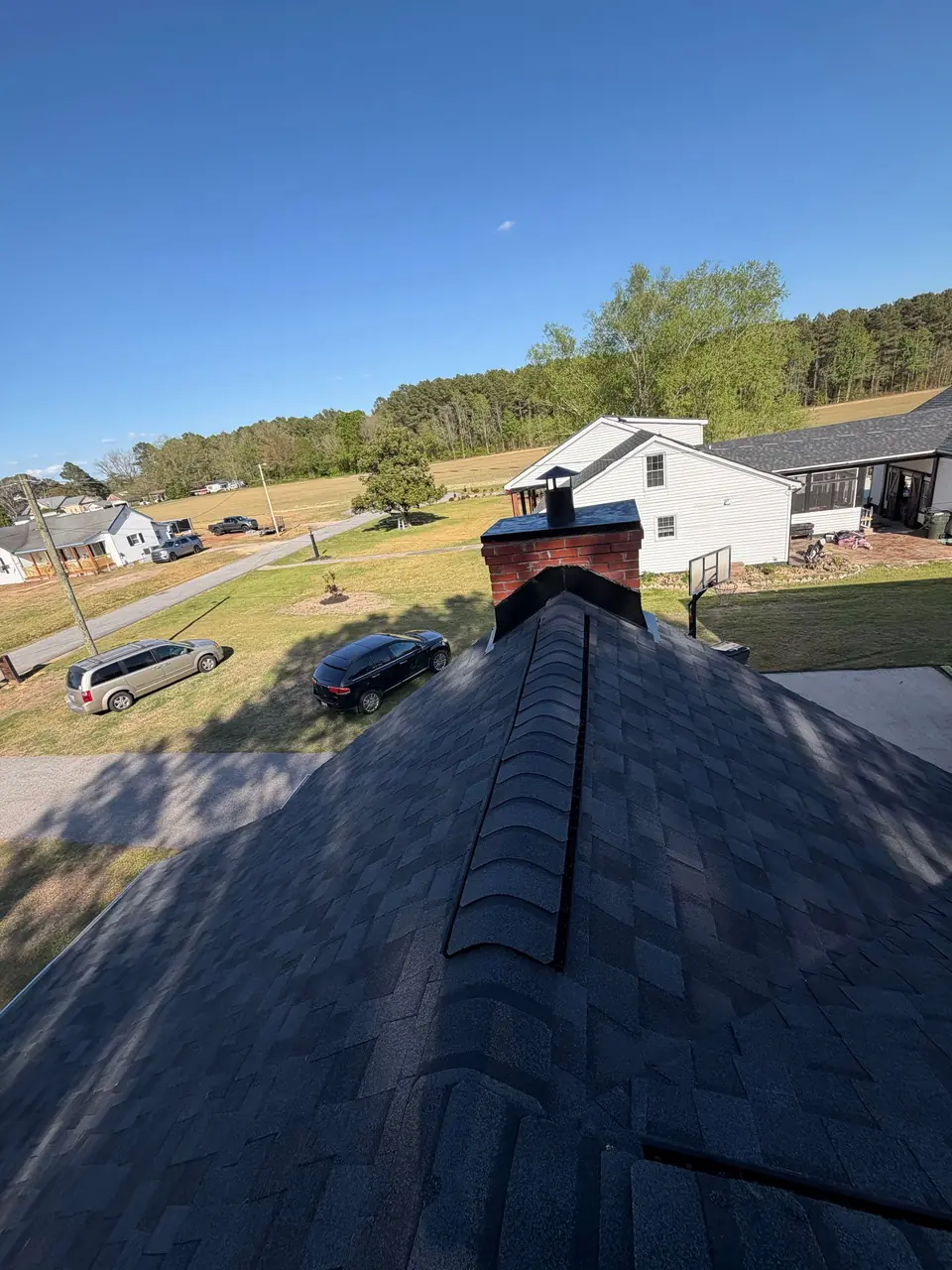 Brick chimney and new charcoal shingle ridge on a home in Macclesfield, NC