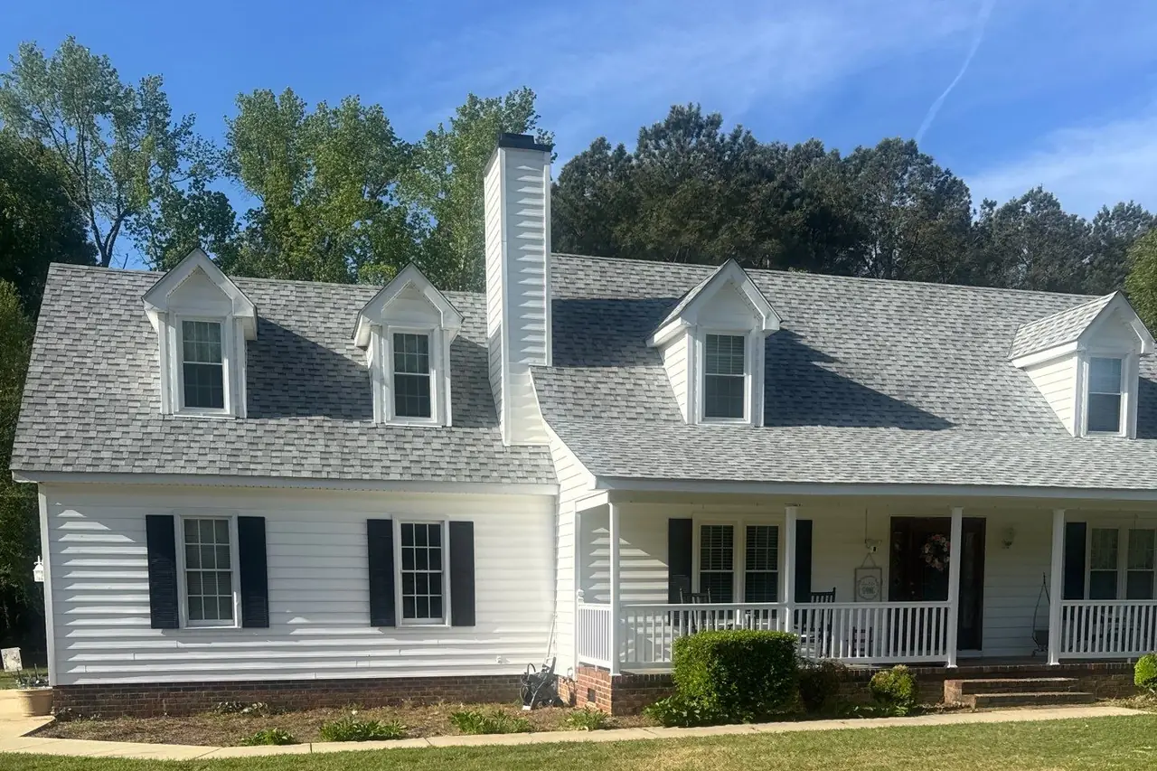 White Cape Cod home in Pinetops, NC with four dormers, a tall chimney and a new light gray architectural shingle roof