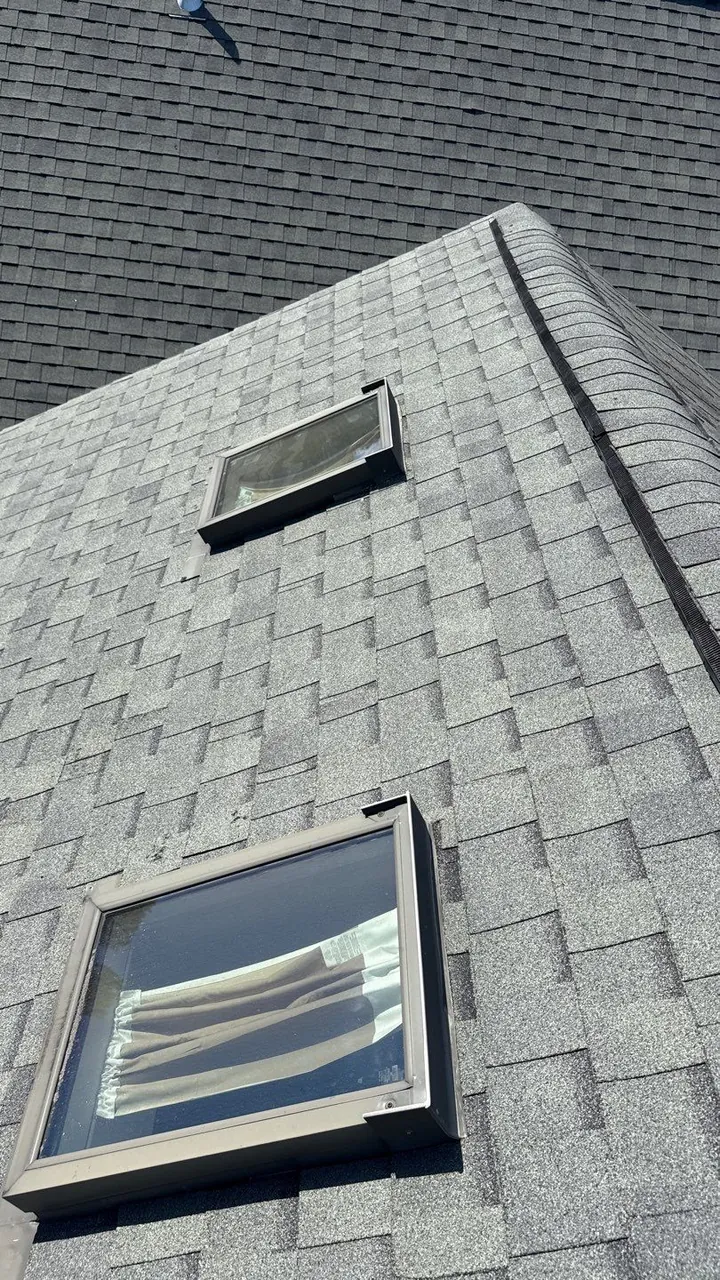 Two skylights set in metal flashing in a new light gray architectural shingle roof in Washington, NC