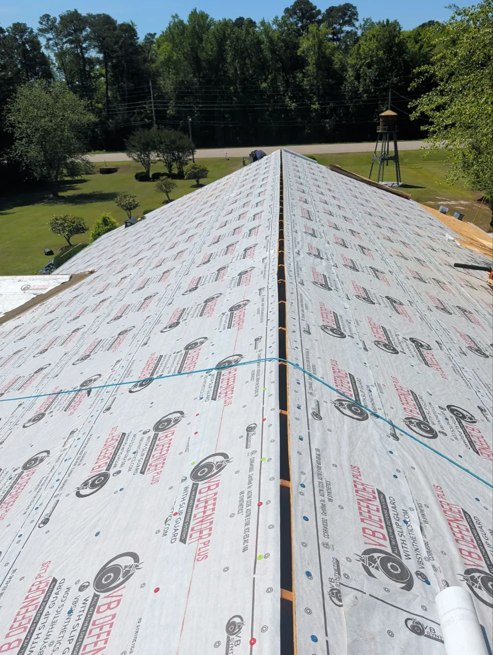 Long roof covered in VB Defender Plus synthetic underlayment with chalk lines, seen from the ridge, on a home in Washington, NC