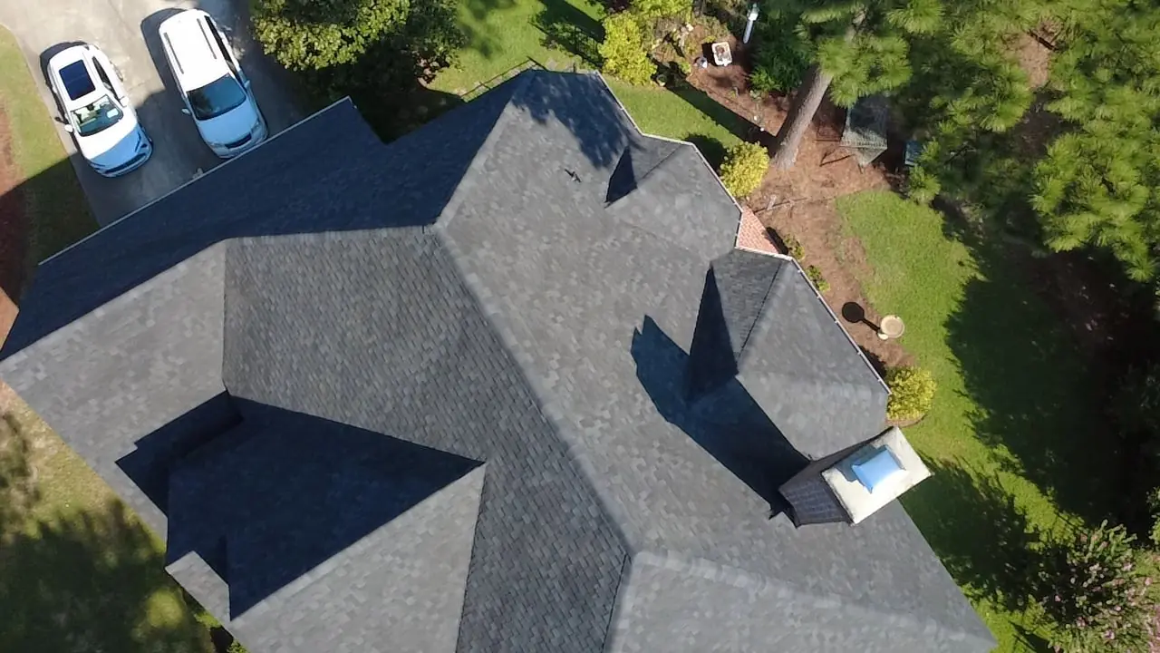 Overhead drone view of a new hip-and-valley shingle roof on a brick home in Wilson, NC