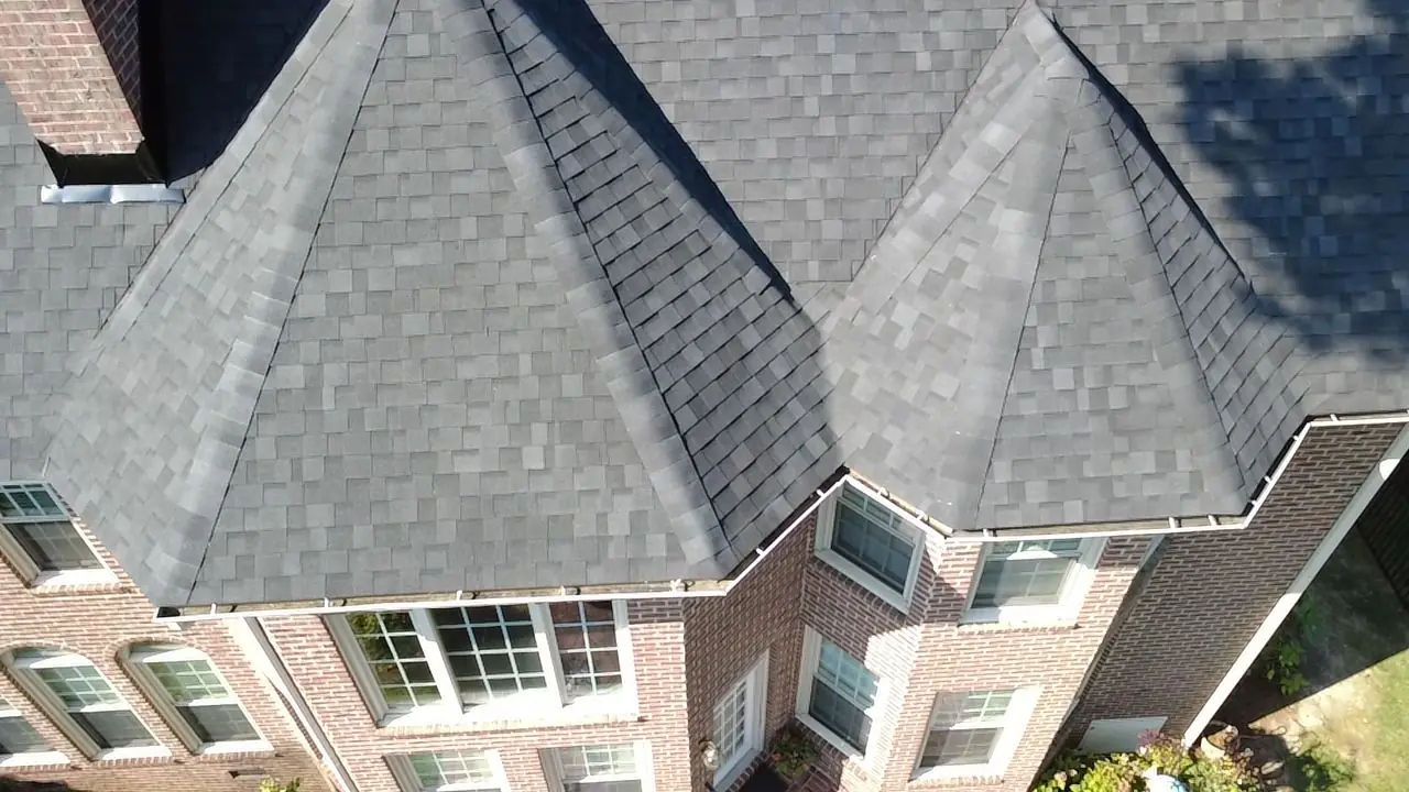 Drone view of new shingles over a many-sided bay on a brick home in Wilson, NC