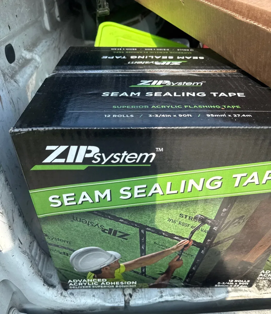 A carton of ZIP System seam sealing tape, an acrylic flashing tape, staged in the crew's van at the job site.