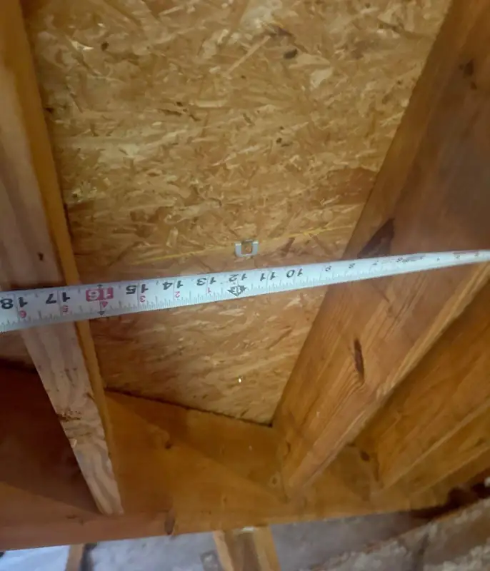 Rafter spacing documented with a tape measure from the attic